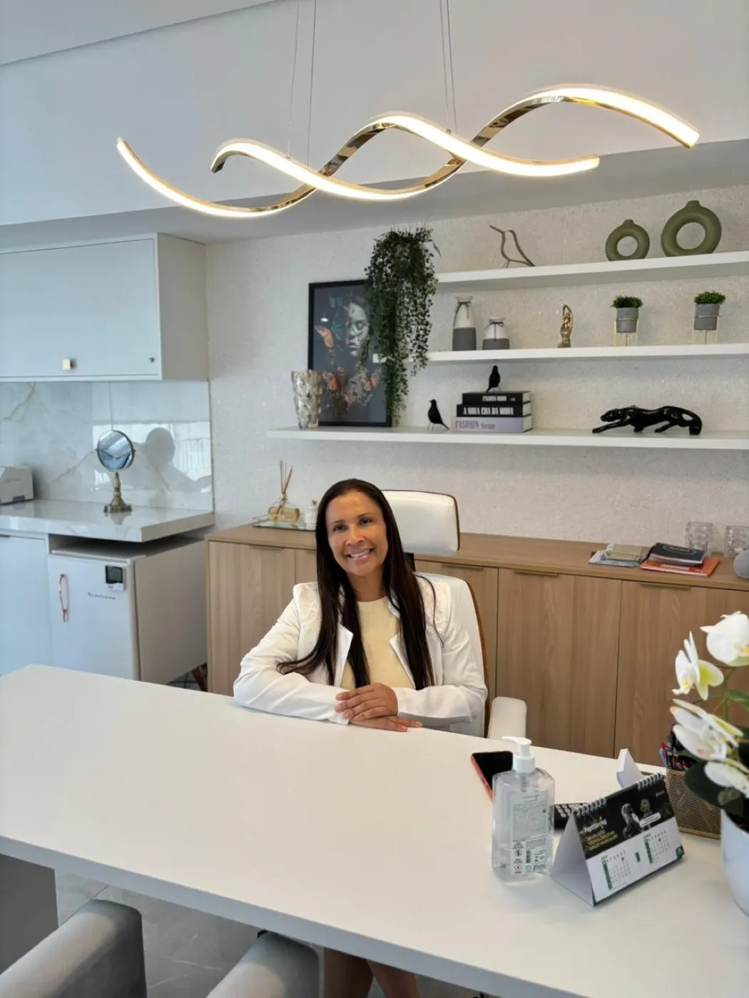Consultório com mesa de atendimento e iluminação indireta