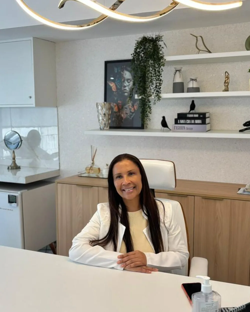 Dra. Cleide Abreu no consultório, à mesa de atendimento